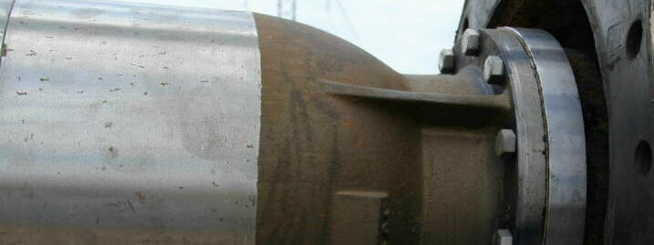 A close-up shot of a pipe flange, showing the robust metal construction and bolts.